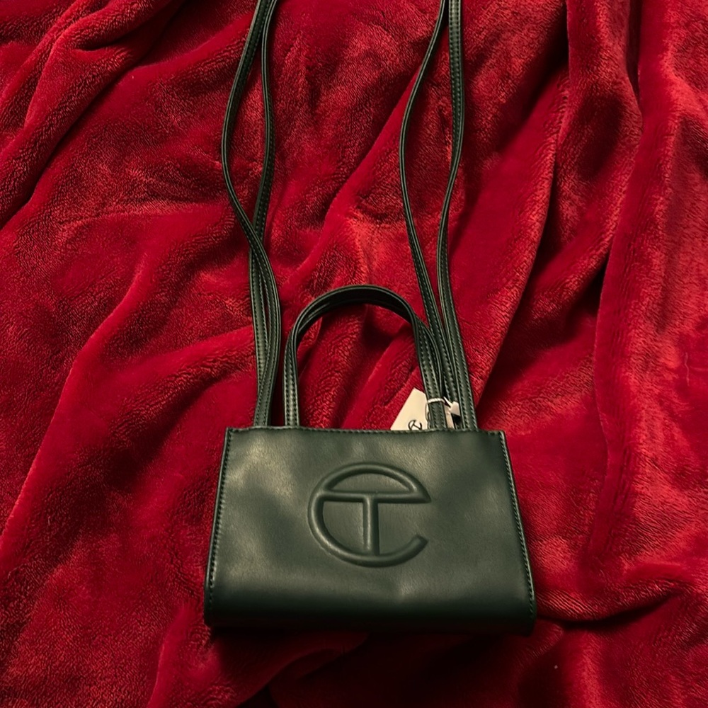 Small dark green tote bag with straps for shoulders